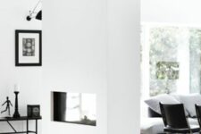 a white dual-sided fireplace separates the living room and entryway and gives coziness and a welcoming feeling to both