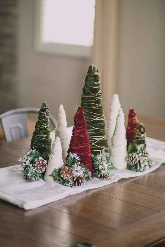 a white napkin, snowy pinecones and evergreens, red, green and white velvet ribbon Christmas trees for a lovely holiday arrangement