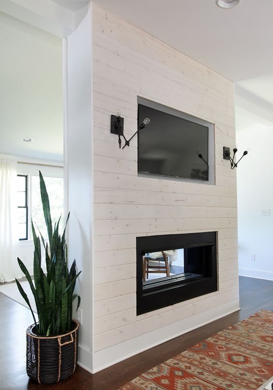 a whitewashed built-in fireplace that gives a cozy feel to both the living room and dining room