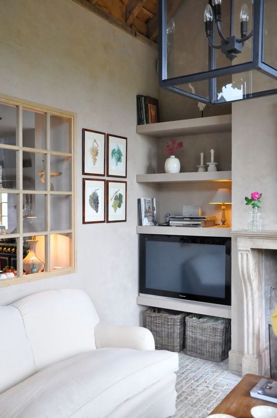 a window with light-stained frames connects the kitchen and the living room and lets light inside