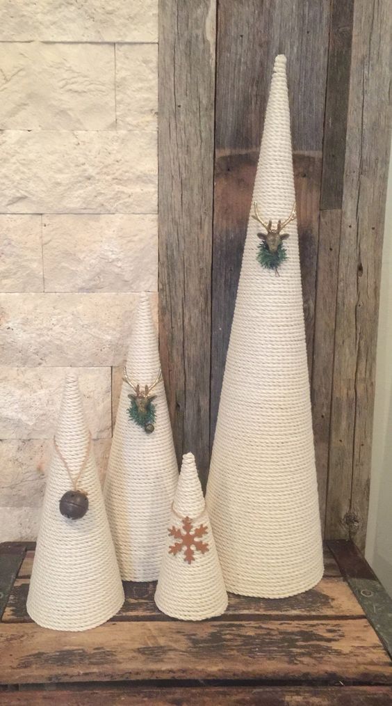 white rope cone Christmas trees decorated with a snowflake, a bell, deer heads and greenery look very cool and bold
