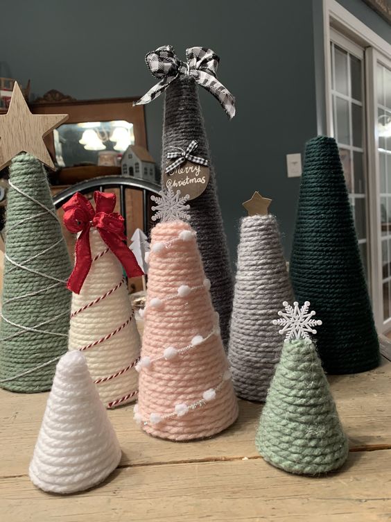 yarn cones wrpaped with pompoms and threads, topped with stars, snowflakes, bows and other stuff are simple and cool Christmas trees