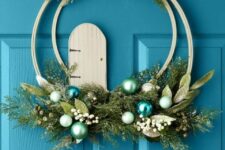 03 a bold double embroidery hoop Christmas wreath with greenery and foliage, pastel and blue ornaments, berries and a ribbon