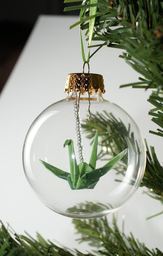a clear Christmas ornament with a green paper crane is a cool idea as cranes in origami symbolize happiness