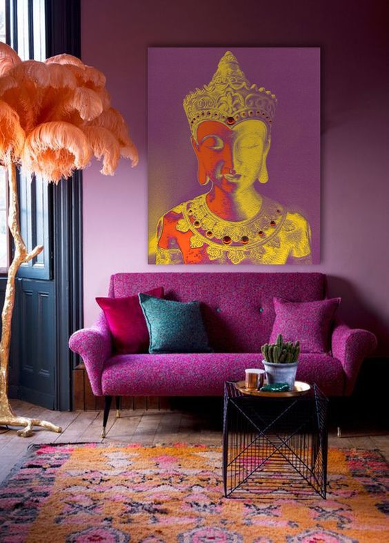 a vibrant magenta living room with a magenta sofa and bold pillows, a side table, a colorful rug and a brigth print looks very whimsical
