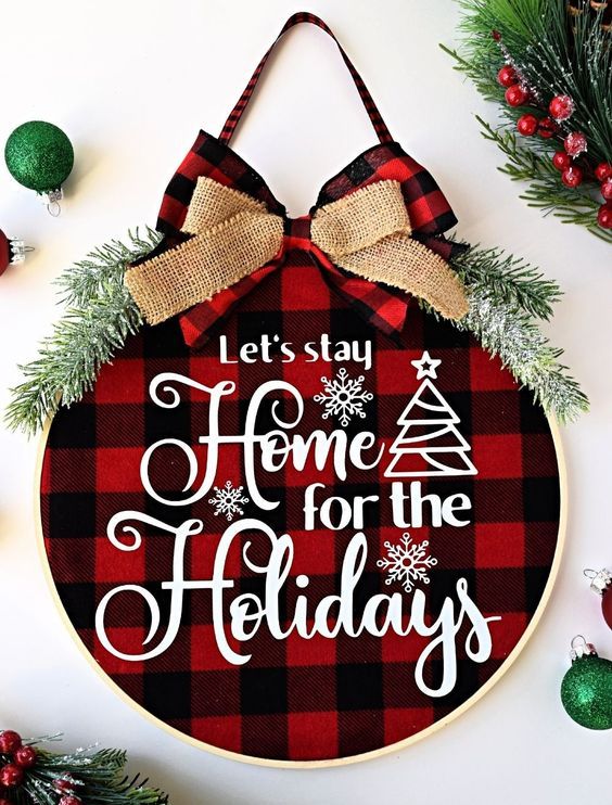 a cozy Christmas wreath with red plaid fabric, white letters, evergreens and a couple of bows on top is amazing