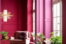 05 a bright magenta space with molding, arched windows, a lilac chair and a coffee table plus some potted plants
