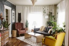 06 a nostalgic living room with a black limewash wall, a burgundy and yellow chair, a black leather sofa, a rattan table and some boho decor