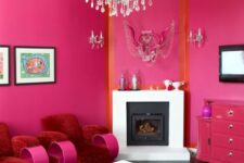 08 a magenta and orange living room with a built-in fireplace, red and pink furniture, a crystal chandelier and a bold rug