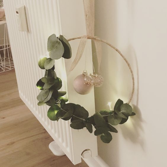 a modern Christmas wreath of an embroidery hoop, eucalyptus, mercury glass and pearl ornaments is a cool decoration