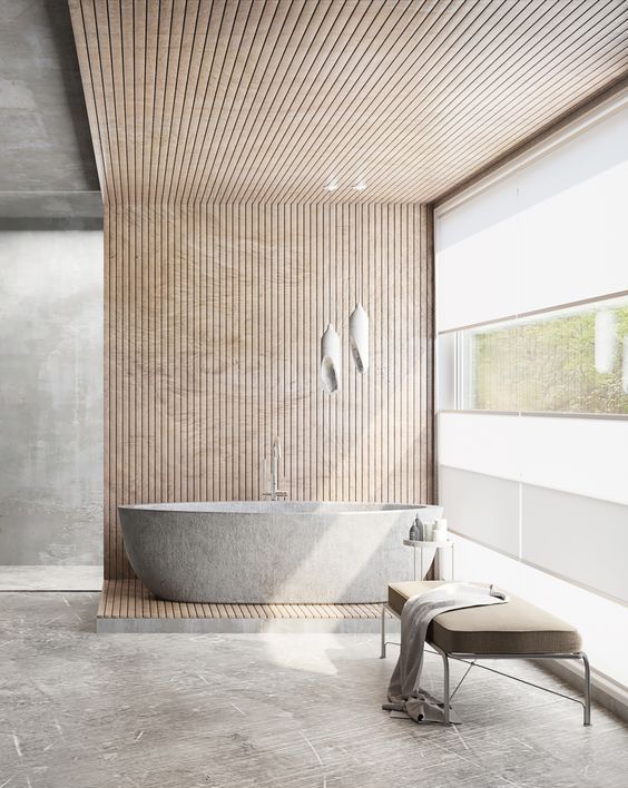 a neutral Japandi bathroom with a glazed wall, an oval stone tub, wooden slabs that cover the wall and ceiling and an upholstered bench