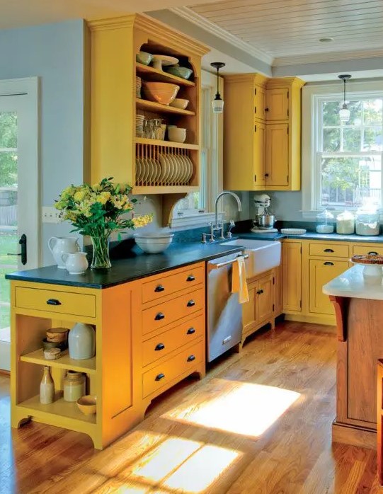 a sunny yellow kitchen with black coutnertops, a wooden kitchen island looks very inspiring, bold and cool