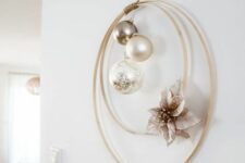 10 a modern laconic Christmas wreath with metallic and neutral ornaments and a faux poinsettia is a lovely wall decor idea
