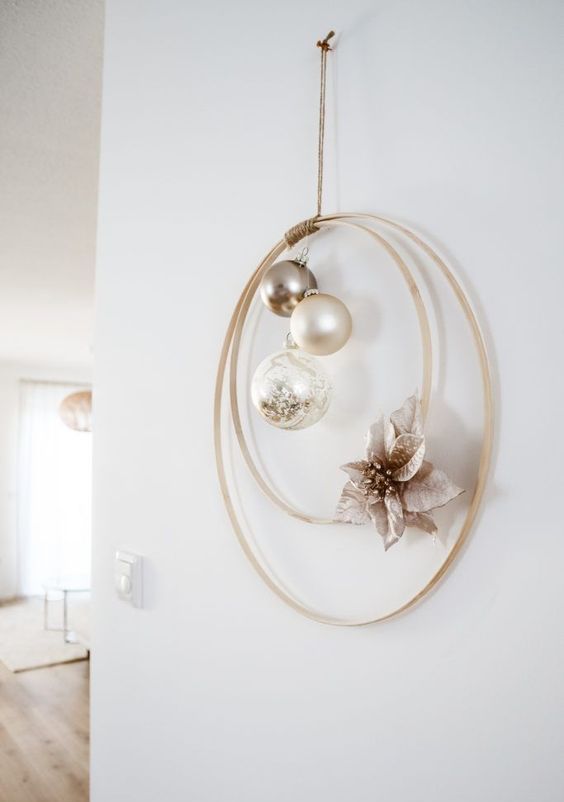 a modern laconic Christmas wreath with metallic and neutral ornaments and a faux poinsettia is a lovely wall decor idea