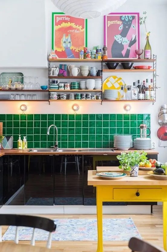 a glossy black kitchen with butcherblock countertops and an emerald tile backsplash and a yellow kitchen island for a lovely look