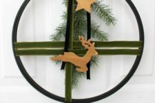 11 a modern Christmas wreath of an embroidery hoop, green and black velvet ribbons, evergreens, wooden stars and a deer