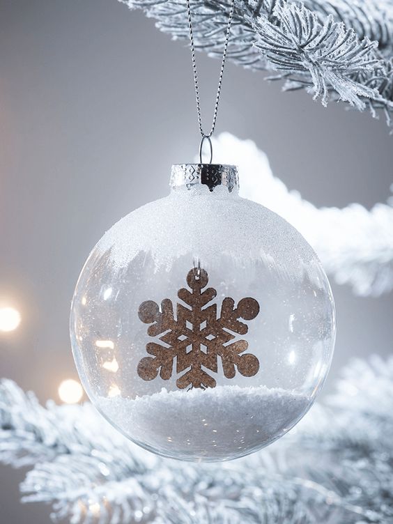 a frosty glass Christmas ornament with faux snow inside and a touch of frost on top plus a gold snowflake