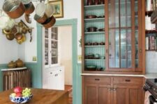 14 a chic vintage kitchen with mint green paneling, stained vintage furniture, a folding table as a kitchen island, a hanger with pans