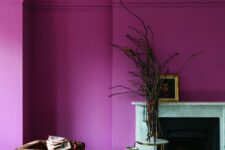 14 a magenta to hot pink space with a fireplace, a bold printed chair, a couple of coffee tables and some branches plus artwork