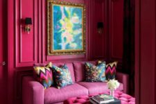 15 a magenta space with a pink sofa, a hot pink ottoman, a black crystal chandelier and a statement artwork is amazing