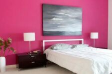 16 a minimalist bedroom with a magenta accent wall, a simple bed and nightstands, a table lamp and a moory artwork