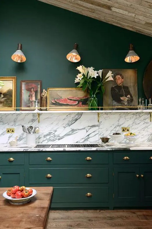 a super elegant vintage kitchen with forest green cabinets and a grey marble backsplash creates a wow effect