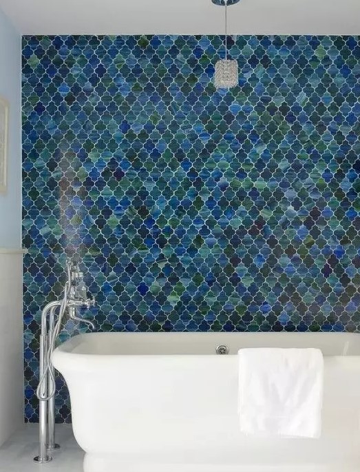 a contemporary bathroom with a fantastic blue and green arabesque tile accent wall plus a white chic bathtub is amazing