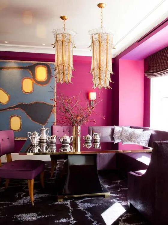 a refined dining space with magenta walls, unique gold chandeliers and purple furniture plus a statement rug