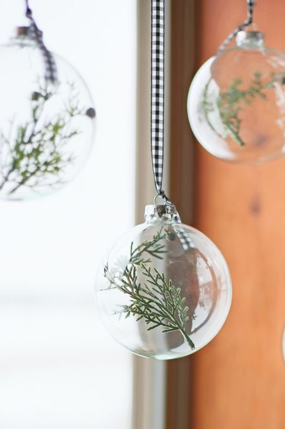 clear glass Christmas ornaments with greenery on buffalo check ribbons are great for adding an airy touch to the space