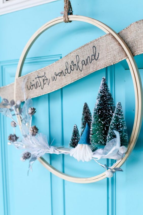 an embroidery hoop Christmas wreath with bottle brush trees, a burlap ribbon and snowy pinecones is cool