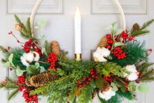 24 an embroidery hoop Christmas wreath with evergreens, pinecones, cotton, berries, a candle in the center is a bold idea