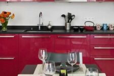 25 a fantastic magenta kitchen with black countertops, a matching open shelf, a black and white tablescape