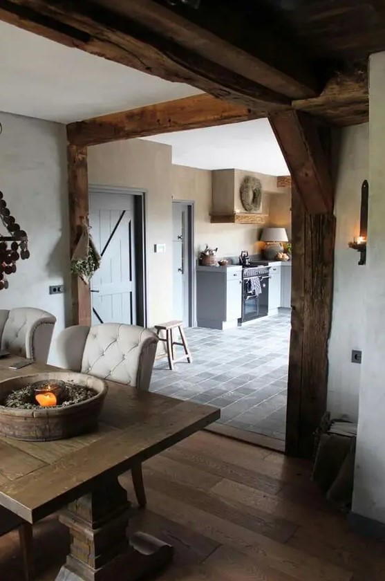 a rough wood ceiling and beams, a vintage heavy wooden dining table and floor bring ultimate coziness to the space