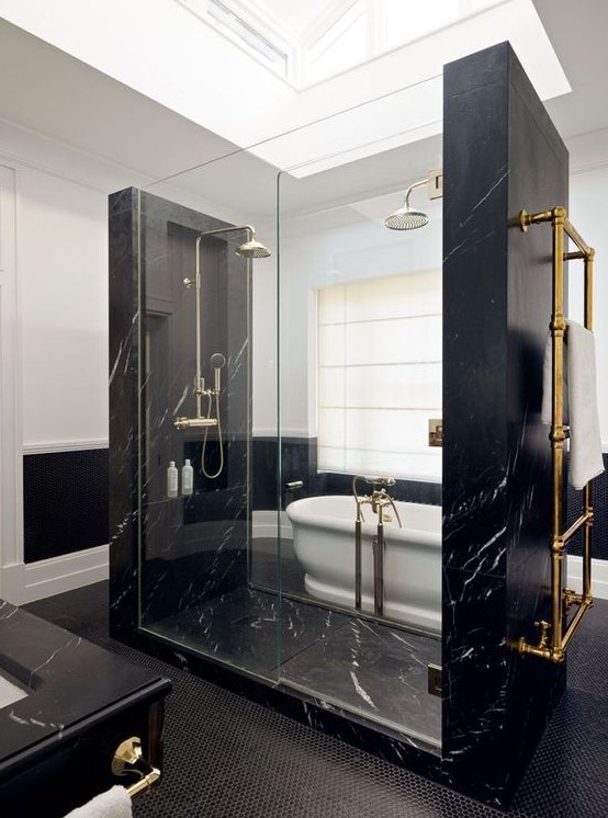 pure elegance and drama in this bathroom done with black marble, black penny tiles and a white vintage tub