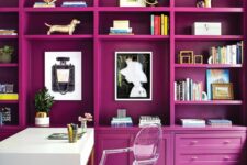 29 a jaw-dropping home office with a magenta storage unit that creates an ambience, a white desk and a clear chair, a gold chandelier