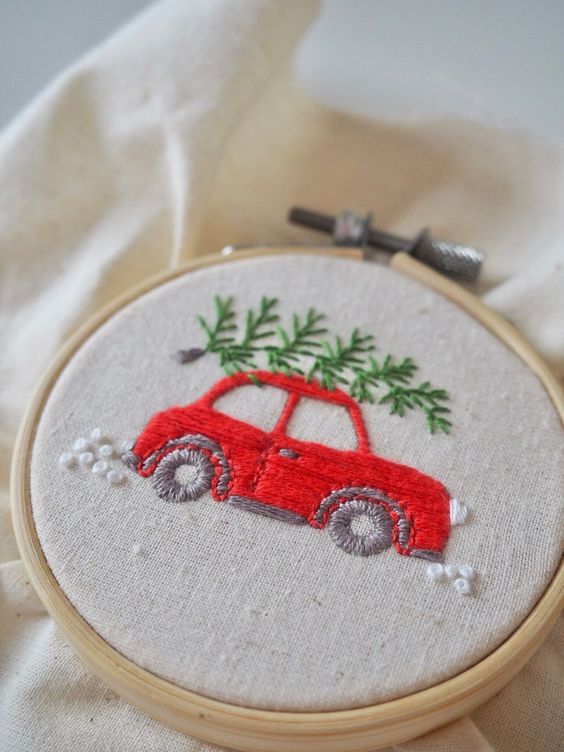 a fun and cool embroidery hoop Christmas ornament with a red car and a tree embroidered is an awesome decor idea