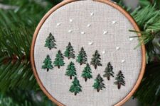 31 a lovely embroidery hoop Christmas ornament with embroidered trees and snow is a cool rustic decoration for the holidays