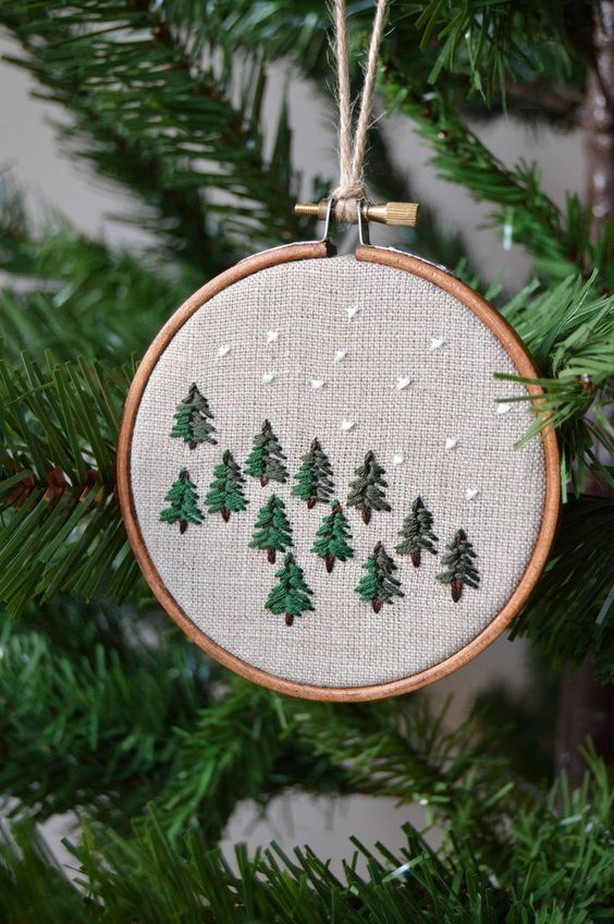 a lovely embroidery hoop Christmas ornament with embroidered trees and snow is a cool rustic decoration for the holidays