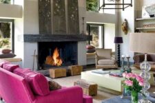31 a modern living room with a fireplace, a magenta sofa, floral artworks, a creative table with wood, tree stumps and catchy lamps