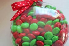 33 M&Ms fill ornament with a red bow is a lovely Christmassy idea in traditional colors, and it’s very easy to make