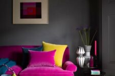 33 a moody living room with grey walls, a magenta sofa, a yellow tufted ottoman, a printed rug, chic vases and candles