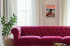 34 a neutral living room with a magenta sofa, a tiered coffee table, a chandelier, a bold artwork and a potted plant