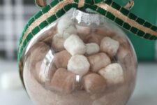 36 a hot cocoa Christmas ornament topped with a green and gold ribbon bow is a cool gift and decoration for the holidays
