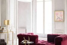 36 a neutral refined living room with molding on the walls, a magenta sofa, a chic coffee table, a console and a printed chair