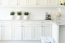 37 a vintage white kitchen with a white tile backsplash, stools and much storage space