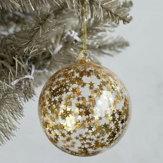 a clear glass Christmas ornament fully covered with gold stars is a lovely idea for glam holiday decor