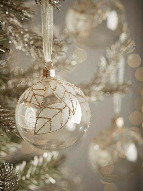 a clear glass Christmas ornament with white leaves and gold glitter accents are amazing for the holidays