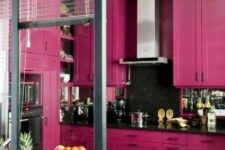 41 a stylish magenta kitchen with shaker cabinets, black countertops and a mirror backsplash, built-in appliances and a glazed wall
