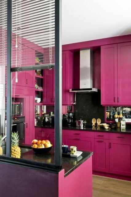 a stylish magenta kitchen with shaker cabinets, black countertops and a mirror backsplash, built-in appliances and a glazed wall