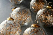 43 clear glass Christmas ornamens decorated with gold snowflakes look magical and will bring this magical touch to your tree